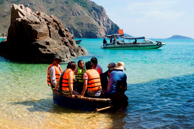 Description: Để ra được thuyền, du khách phải lên những chiếc thúng hoặc phà tự chế để ngư dân dầm mình trong nước kéo ra thuyền nằm cách 100 m. Ảnh: Nhi Nguyễn.